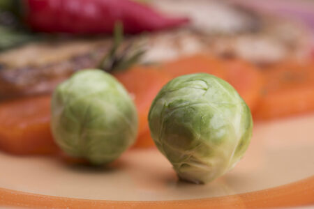Brussels sprouts on an orange plate with meat and vegetablesの写真素材