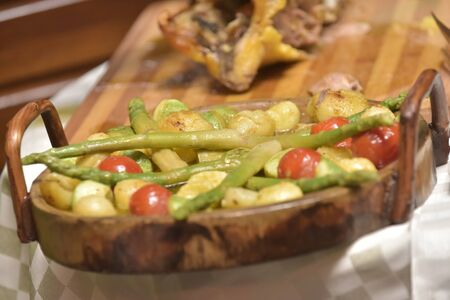 Grilled chicken and vegetables over a wooden plateの写真素材