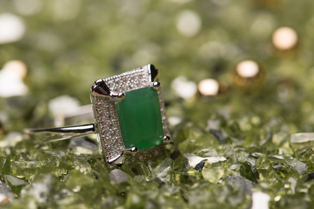 Green stone ring on a green sparkling backgroundの写真素材