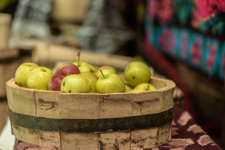 Green and red apples in a wooden dish and  handmade vintage backgroundの写真素材