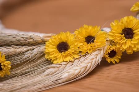 Wheat and yellow daisies arranged on  tableの写真素材