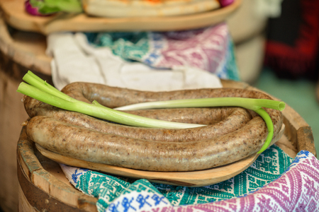 Appetizers with sausages and green onions  on wooden plateの写真素材