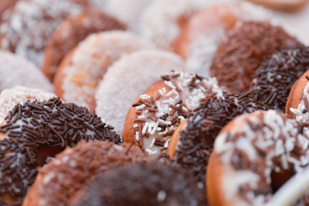 Different flavored doughnuts covered  with white and brown chocolate for candy barの写真素材
