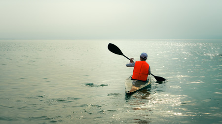 A single canoe rowing on the surface of the waterのeditorial素材