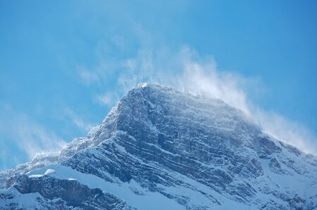 Snow blowing off top ridges of Mount Rundle in Banff National Park, Canadaの写真素材