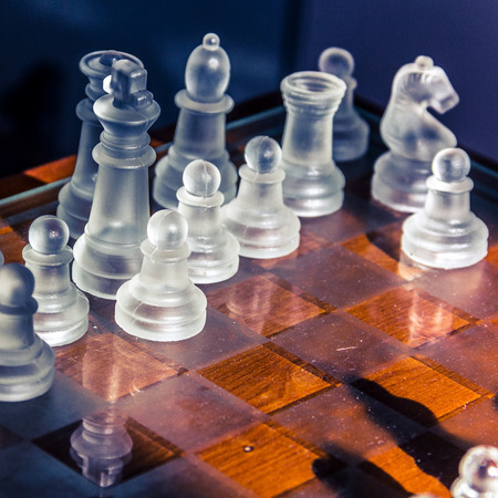 transparent glass chess board and figures with reflectionsの写真素材