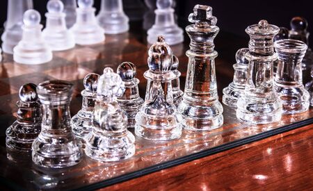 transparent glass chess board and figures with reflectionsの写真素材