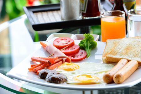 The nice breakfast is served on the glass table