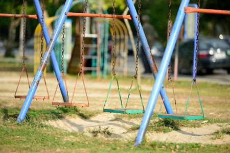 The unoccupied swing is on the playground.の写真素材