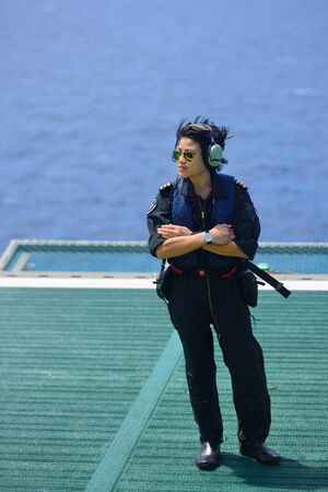 asian woman offshore helicopter pilot is standing on offshore oil rigの写真素材