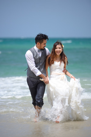 happiness and romantic scene of love just married young couple walking and at beautiful beachの写真素材