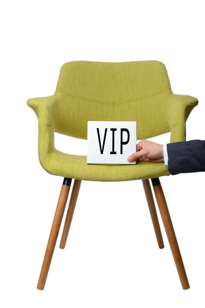 businessman hold white paper note "VIP" on modern green armchair wooden leg isolated on white background,service conceptの写真素材