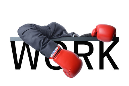 tired businessman with red boxing glove after fight with hard workの写真素材