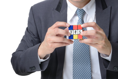 businessman hand playing square puzzle for concept solve solution isolated on white backgroundの写真素材