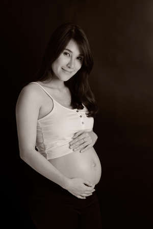 Portrait of the young happy smiling pregnant asian womanの写真素材