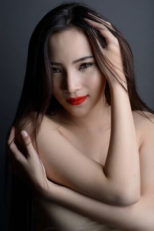 studio shot of portrait beautiful asian woman with strapless dress on dark background.の写真素材