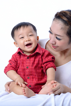 the asian baby boy is smiling and laughing with his motherの写真素材