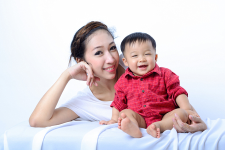 Portrait asian  baby boy and mother are smiling and laughing on white backgroundの写真素材