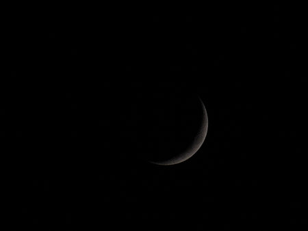 a half ring moon in dark black sky