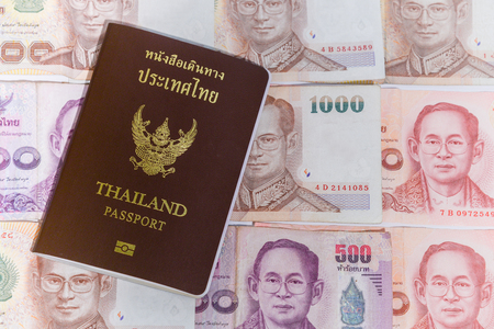 Thailand passport with white background baht banknotes and coinsの写真素材