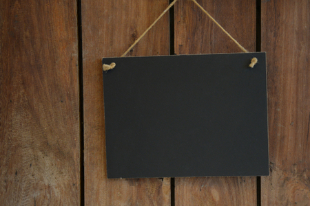 Blackboard sign on wooden background with copy space for advertisingの写真素材