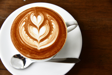 closeup cup of coffee latte art and mocha on old brown wooden background square frame image.の写真素材