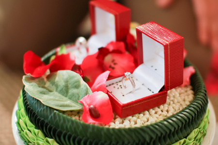 Thai wedding rings in an open box on traditional Thai style garland.engagement ring in Thai wedding ceremonyの写真素材