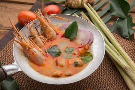 Tom yam kong or Tom yum, Tom yam is a spicy clear soup typical in Thailand Cuisine. Tom yam kong on wooden table. Thai food.の写真素材