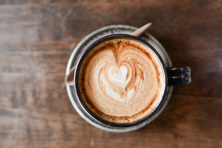 Coffee cup cappuccino, cup of coffee on brown wooden table.Soft focus on latte coffee cup - vintage effect process picturesの写真素材