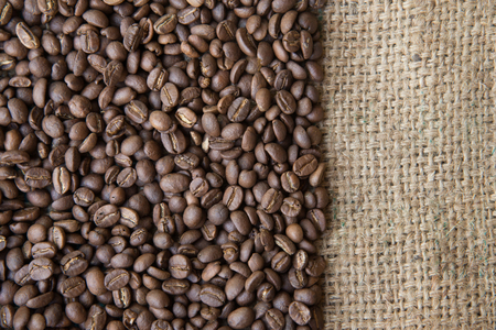 coffee beans background on sack cloth.Texture with copy space of roasted coffee beans on gunny bagの写真素材