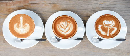Coffee cup with latte art on wooden table in vintage coffee shopの写真素材