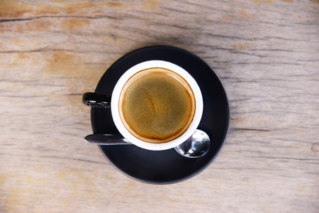 black coffee in black coffee cup for breakfast or coffee break time on wooden tableの写真素材