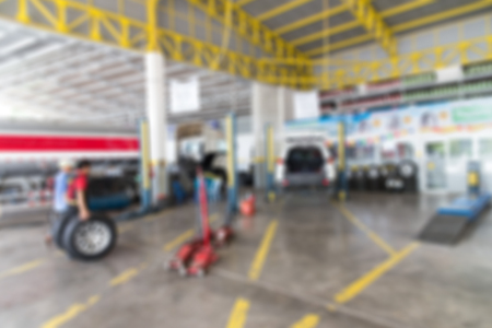Blurred background of Garage service workshop hydraulic platform elevator.Car technician repairing the car in the garage.の写真素材