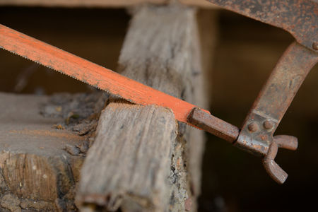 close up of Carpenter sawing a board with a hand wood sawの写真素材