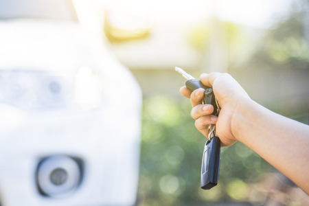 woman hand holding the remote control to lock the car door.car security anti thief alarm systemの写真素材