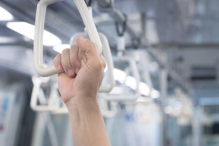 People Hand holding Handle on the train during rush hour.Handle loop in the trainの写真素材