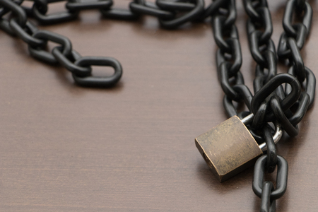 lock and metal chain on wooden background.vintage lock is a symbol of security and protectionの写真素材