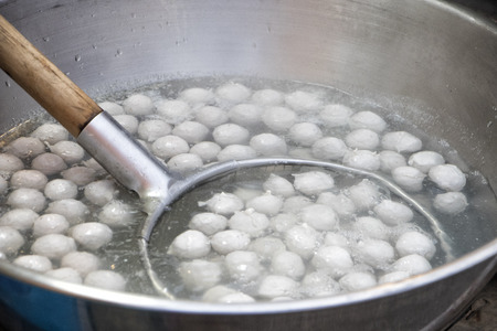 Cooking meat ball in hot pot.Boiled meat ball in hot water in asia tradition street marketの写真素材