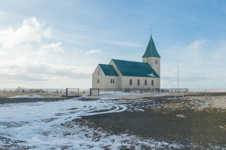 rural scene church in countryside late winter under blue sky in background.christian church in the north of iceland.の写真素材