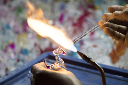 Handicraft from glass blowing.Worker use high temperature to melting glass and forms it shape to...