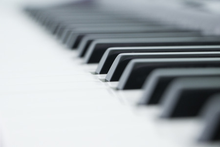 Piano is a musical instrument classified as a percussion instrument that is played by pressing keys on a keyboard. Each key is a lever that makes a hammer inside the piano hit a string inside, producing a sound. Each string has a different length and so produces-a different note.の写真素材