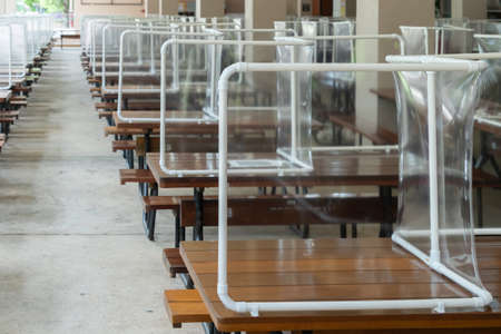 Preventing the spread of Covid-19 coronavirus in schools and universities by using plastic sheets divide the area in the cafeteria for social distance and new normal life policy in Thailandの写真素材