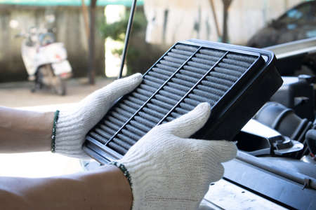 Manual car air filter replacement to maintain engine performance.Air filter is clogged. Causing incomplete combustion in the engine compartmentの写真素材