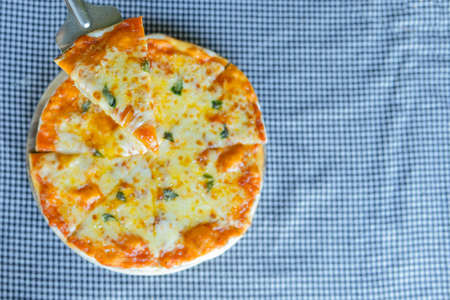 Homemade Pizza made from dough topped with spices like ham, sausage , vegetables and cheeseの写真素材