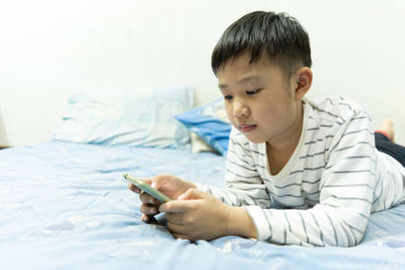 Home school and new normal lifestyle concepts.Asian boy studying through online media and do homework at home due to social distance policy to prevent the spread of the coronavirus(Covid-19)の写真素材