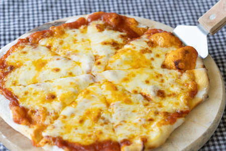 Homemade Pizza made from dough topped with spices like ham, sausage , vegetables and cheeseの写真素材