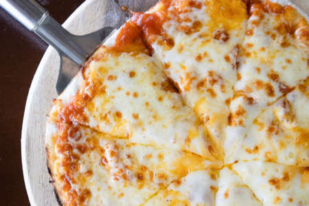 Homemade Pizza made from dough topped with spices like ham, sausage , vegetables and cheeseの写真素材