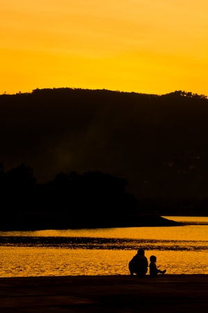 Silhouette of family after sunsetの写真素材