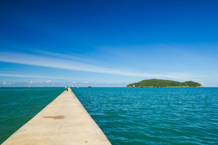 A long and small concrete pier on a seaの写真素材