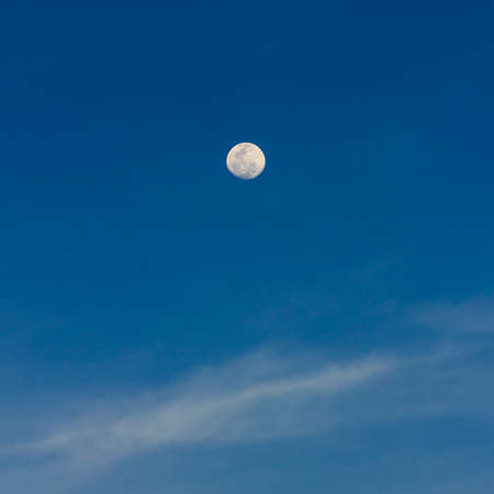 Full moon on the blue sky just before sunsetの写真素材